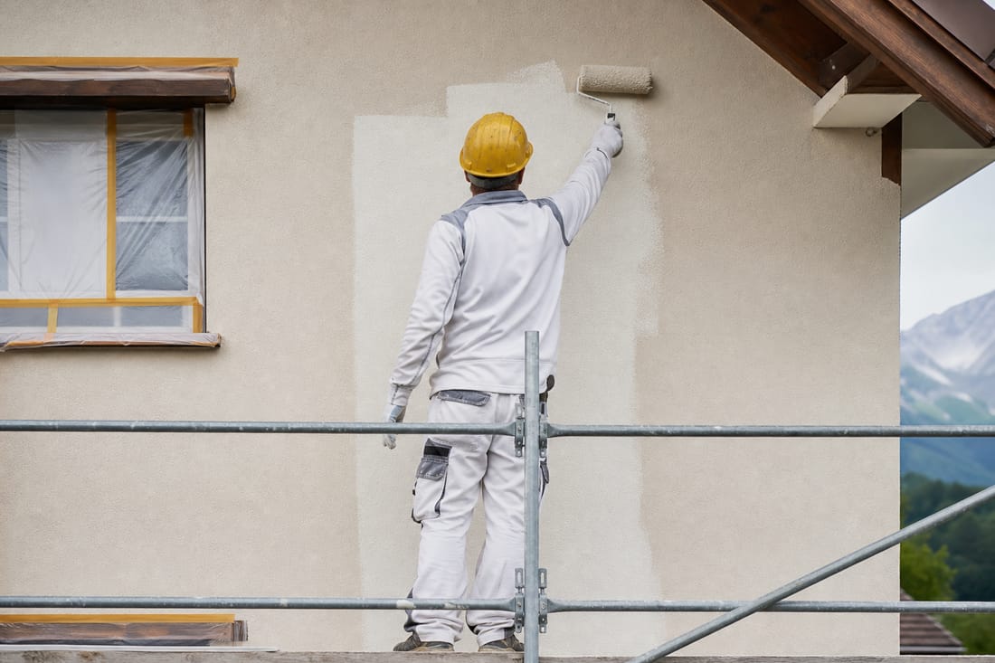 Exemple : ouvrier ravalant une façade depuis un échafaudage